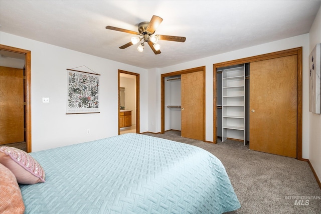 carpeted bedroom with a ceiling fan, two closets, and ensuite bathroom