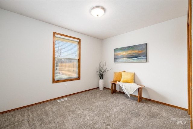 living area with carpet, visible vents, and baseboards