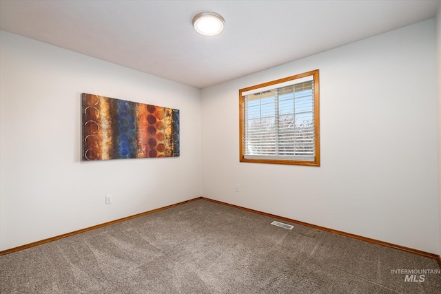 carpeted empty room featuring visible vents and baseboards