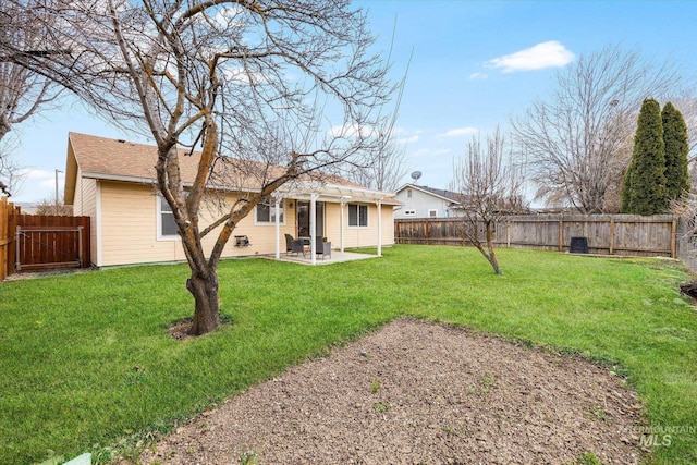 rear view of house with a chimney, a lawn, a patio area, and a fenced backyard