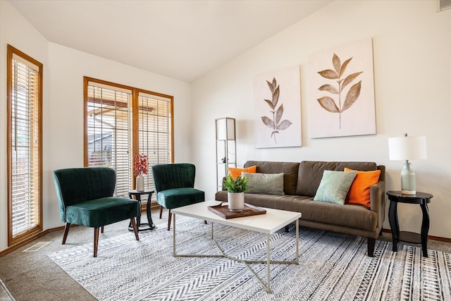 living area featuring carpet floors, visible vents, baseboards, and vaulted ceiling