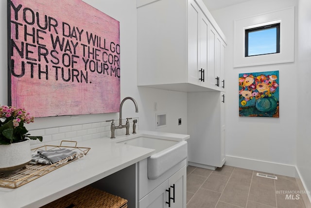 clothes washing area with hookup for a washing machine, electric dryer hookup, sink, light tile patterned flooring, and cabinets