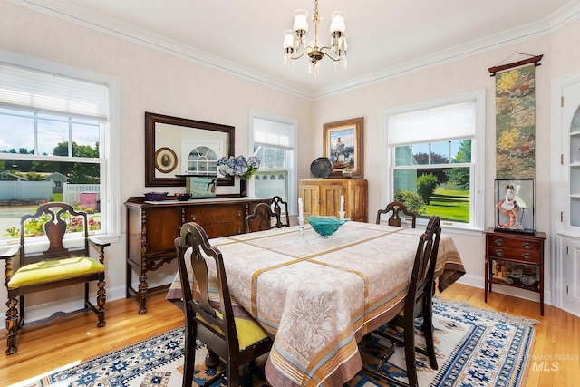 dining space with an inviting chandelier, crown molding, and light hardwood / wood-style floors