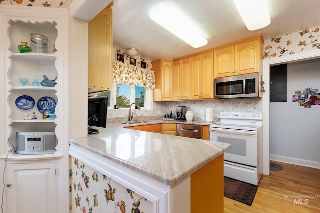 kitchen with sink, appliances with stainless steel finishes, electric panel, light hardwood / wood-style floors, and kitchen peninsula