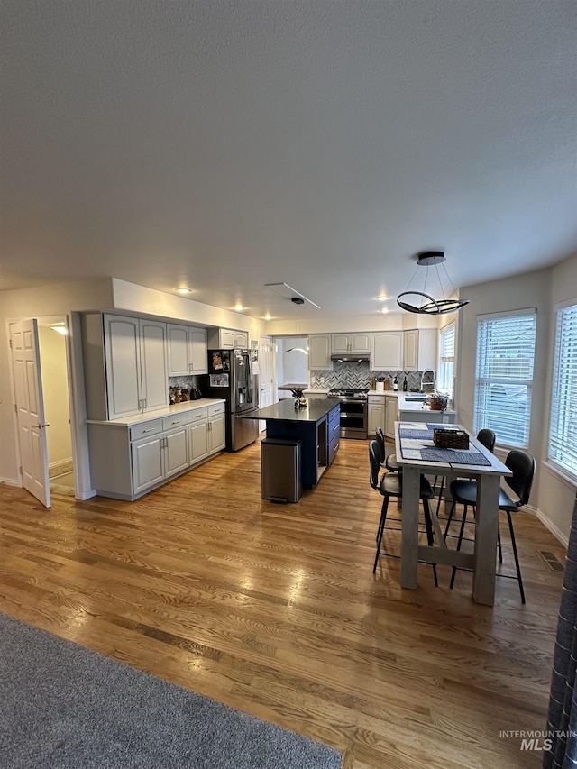 dining space featuring baseboards, wood finished floors, and visible vents