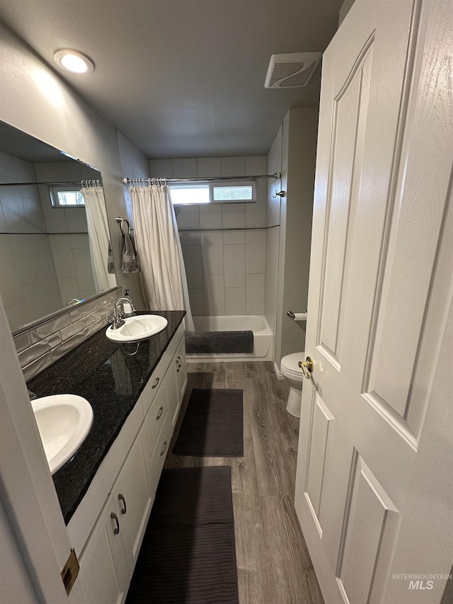 full bathroom with a wealth of natural light, toilet, and a sink