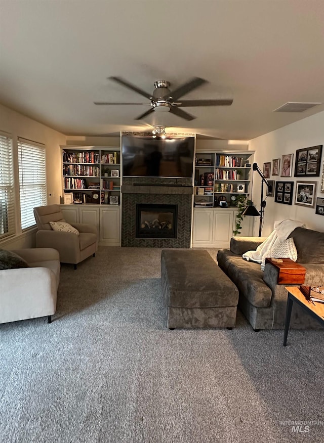 living room featuring a fireplace, carpet floors, visible vents, and a ceiling fan