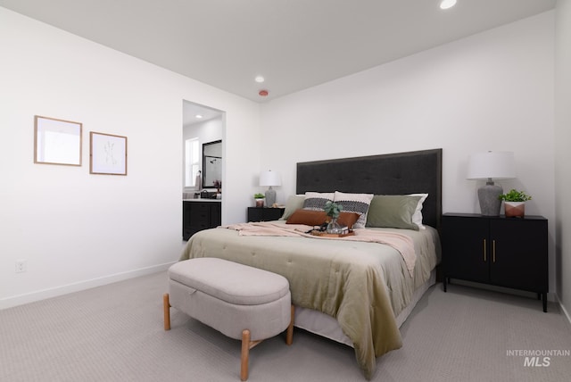 bedroom featuring connected bathroom, recessed lighting, baseboards, and light carpet