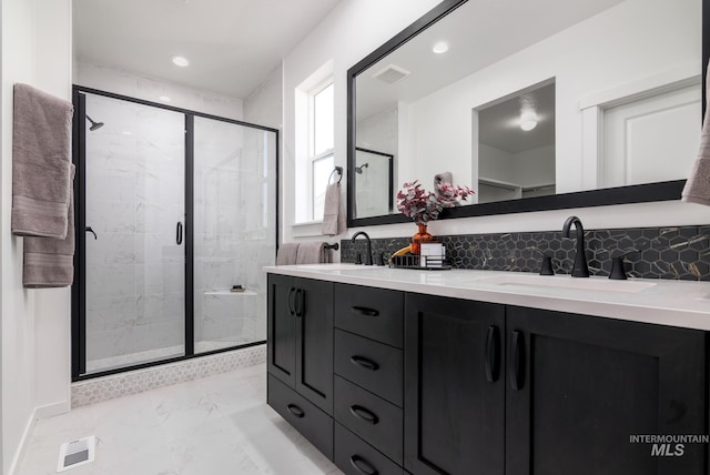 bathroom featuring a stall shower, marble finish floor, a sink, and backsplash
