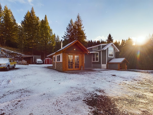 view of front of property featuring a garage, an outdoor structure, and french doors