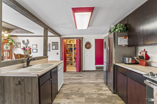 19550 Whitecap Ct, Wilder, ID 83676 - kitchen with a sink, light countertops, light wood-type flooring, white dishwasher, and a textured ceiling