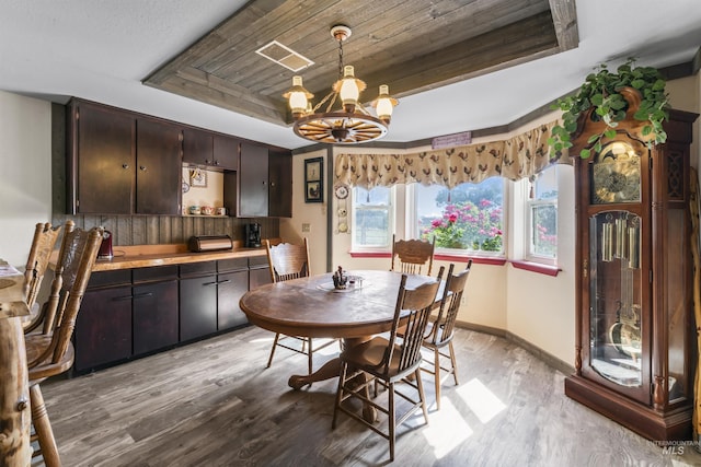 19550 Whitecap Ct, Wilder, ID 83676 - dining space with a tray ceiling, light wood-type flooring, a chandelier, baseboards, and wooden ceiling