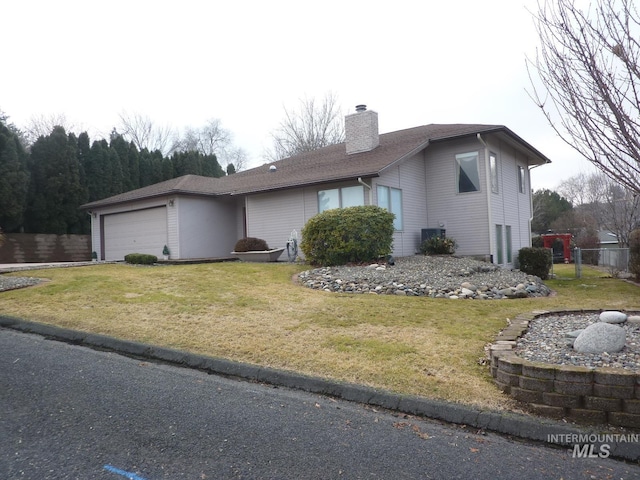 view of front of house with a garage, a front yard, and a chimney