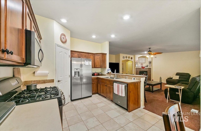 1207 Empire Ct, Caldwell, ID 83607 - kitchen featuring appliances with stainless steel finishes, a peninsula, brown cabinetry, open floor plan, and ceiling fan