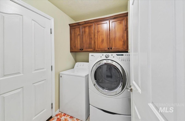 1207 Empire Ct, Caldwell, ID 83607 - clothes washing area featuring washing machine and clothes dryer, cabinet space, and a textured ceiling