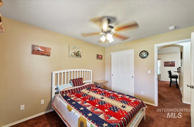 1207 Empire Ct, Caldwell, ID 83607 - bedroom featuring dark carpet, arched walkways, baseboards, and a textured ceiling