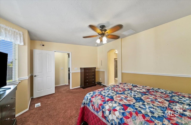 1207 Empire Ct, Caldwell, ID 83607 - bedroom with arched walkways, carpet flooring, baseboards, ceiling fan, and a textured ceiling