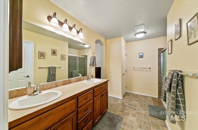 1207 Empire Ct, Caldwell, ID 83607 - bathroom featuring a stall shower, double vanity, stone finish flooring, and baseboards