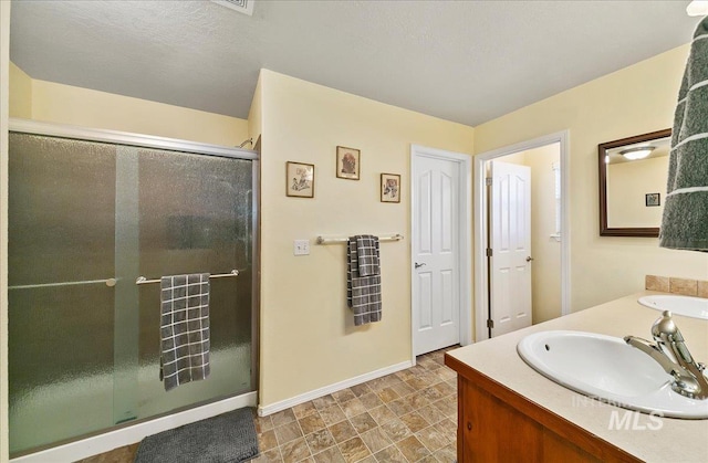 1207 Empire Ct, Caldwell, ID 83607 - full bathroom featuring a shower stall, baseboards, and double vanity