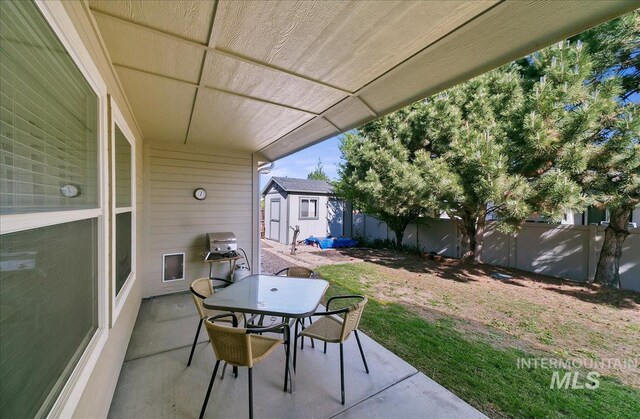 1207 Empire Ct, Caldwell, ID 83607 - view of patio featuring a storage shed, outdoor dining space, a fenced backyard, and an outbuilding
