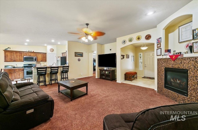1207 Empire Ct, Caldwell, ID 83607 - carpeted living room featuring ceiling fan, arched walkways, a fireplace, recessed lighting, and a sink