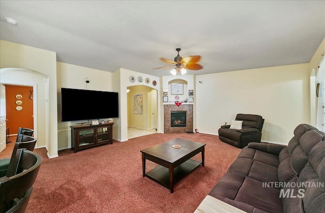 1207 Empire Ct, Caldwell, ID 83607 - living area with arched walkways, ceiling fan, carpet flooring, and a glass covered fireplace
