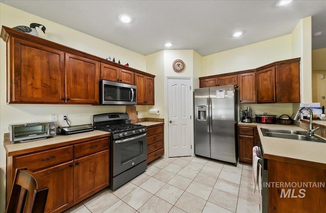 1207 Empire Ct, Caldwell, ID 83607 - kitchen featuring stainless steel appliances, a sink, light tile patterned floors, recessed lighting, and light countertops