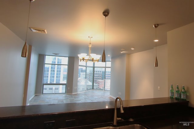 kitchen with a wall of windows, pendant lighting, and an inviting chandelier