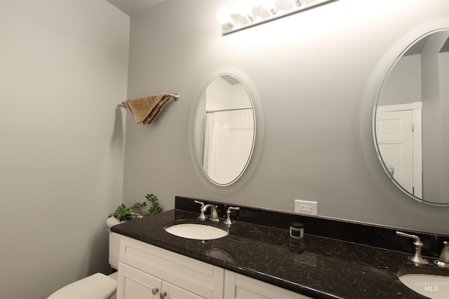 bathroom featuring a shower with shower curtain, vanity, and toilet