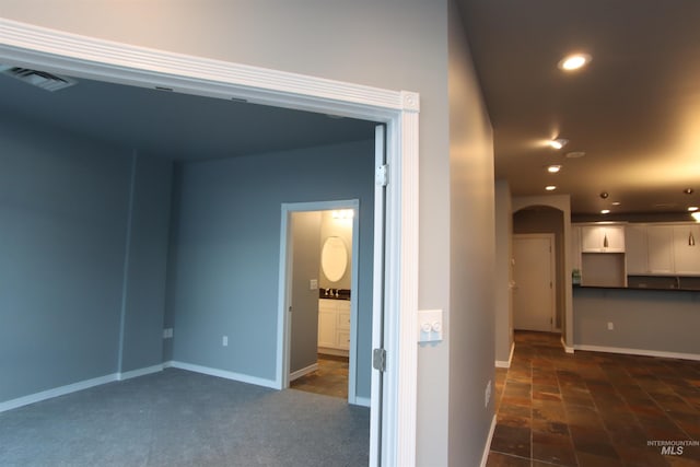 hall with dark colored carpet