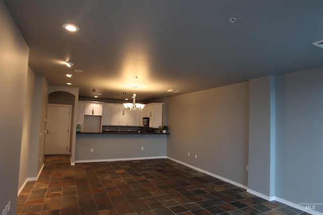 unfurnished living room with a chandelier