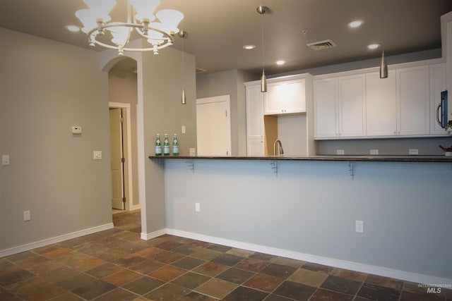 kitchen featuring an inviting chandelier, decorative light fixtures, white cabinetry, and sink