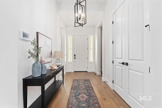 foyer with a notable chandelier and light hardwood / wood-style floors