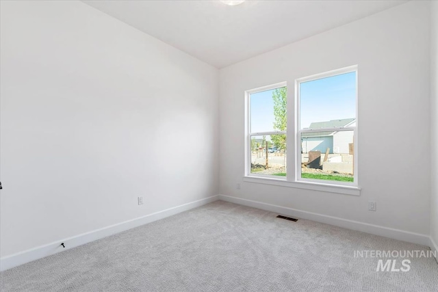 carpeted spare room featuring vaulted ceiling