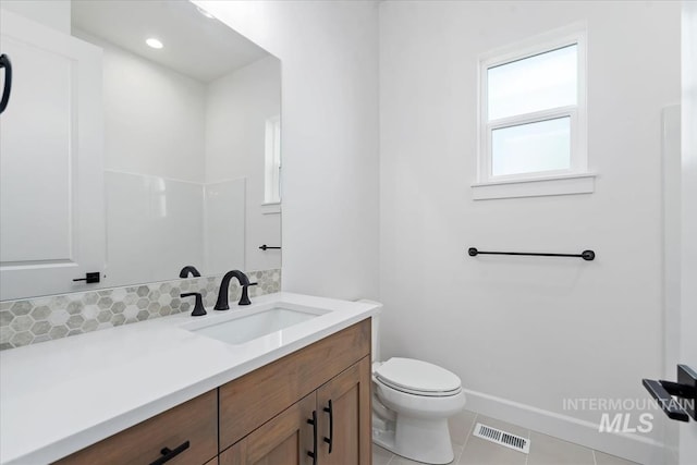 bathroom with tile patterned flooring, vanity, and toilet