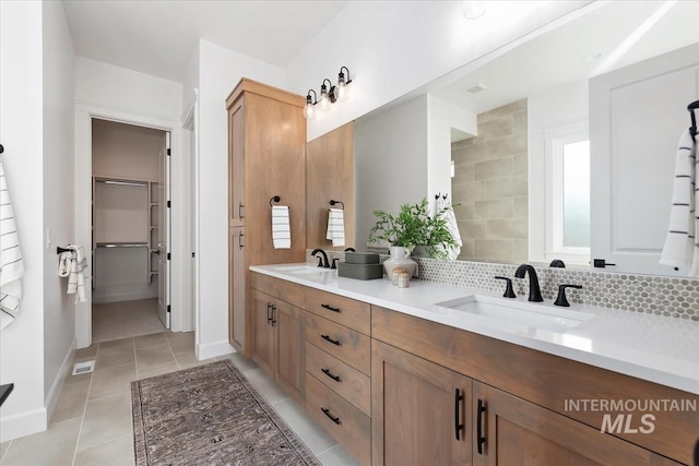 bathroom featuring backsplash, tile patterned flooring, and vanity