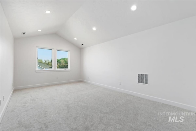 carpeted spare room with lofted ceiling