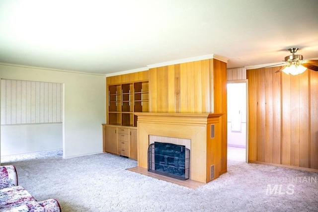 1114 12th Ave, Lewiston, ID 83501 - unfurnished living room featuring ceiling fan, ornamental molding, a tile fireplace, carpet flooring, and wooden walls