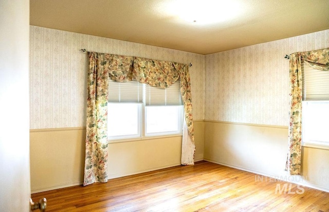 1114 12th Ave, Lewiston, ID 83501 - unfurnished room featuring plenty of natural light, wallpapered walls, and wood finished floors