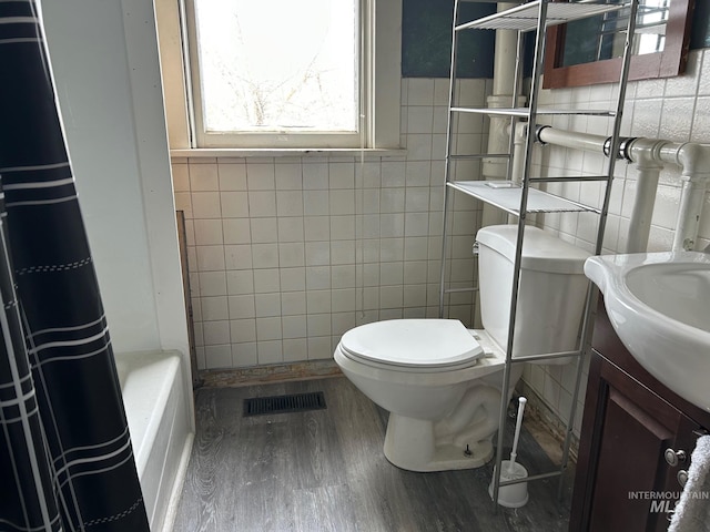 1703 7th Ave, Lewiston, ID 83501 - bathroom featuring vanity, toilet, hardwood / wood-style floors, and tile walls