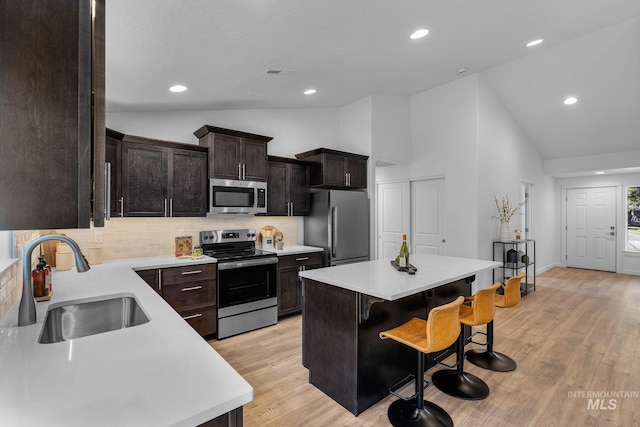11287 Shadow Glen Dr, Caldwell, ID 83605 - kitchen with stainless steel appliances, tasteful backsplash, a breakfast bar, light countertops, and high vaulted ceiling