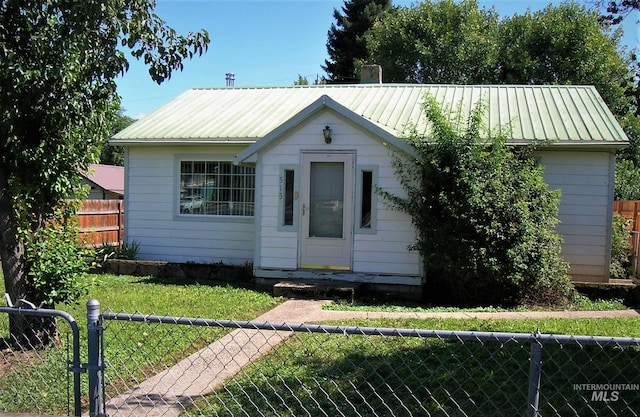 bungalow-style house featuring an outdoor structure and a front lawn