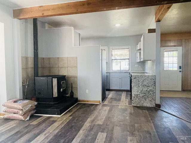 720 W 1st, Fairfield, ID 83327 - kitchen with beamed ceiling, wood finished floors, a wood stove, plenty of natural light, and white cabinetry