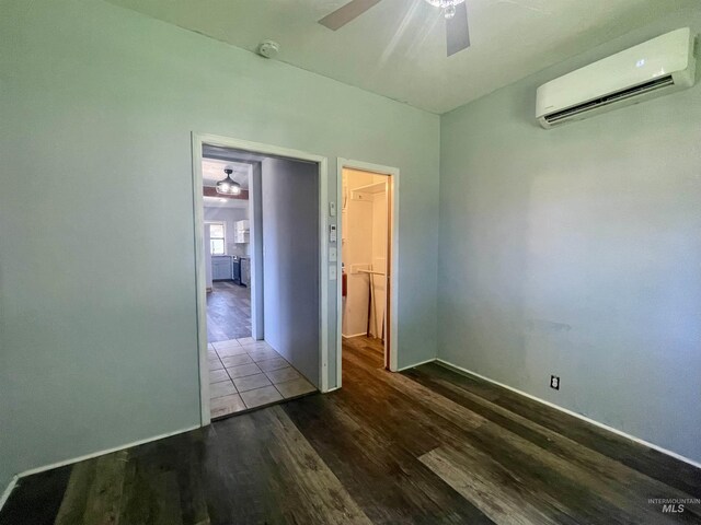 720 W 1st, Fairfield, ID 83327 - empty room featuring a wall mounted air conditioner, ceiling fan, wood finished floors, a smoke detector, and baseboards