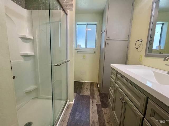 720 W 1st, Fairfield, ID 83327 - full bathroom featuring wood finished floors, a stall shower, and vanity