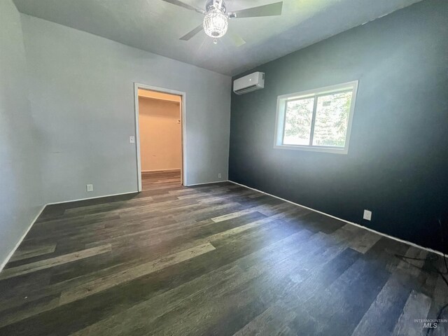 720 W 1st, Fairfield, ID 83327 - spare room featuring a wall unit AC, dark wood-type flooring, a ceiling fan, and baseboards