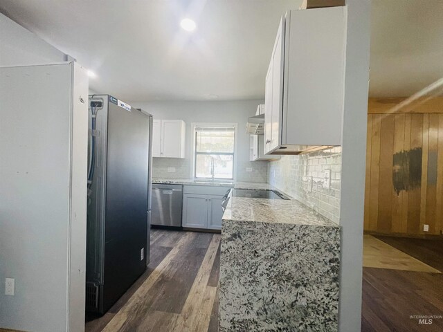 720 W 1st, Fairfield, ID 83327 - kitchen featuring dishwasher, dark wood-style floors, backsplash, freestanding refrigerator, and white cabinetry