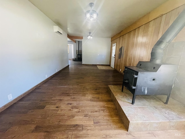 720 W 1st, Fairfield, ID 83327 - kitchen with a wood stove, hardwood / wood-style floors, a wall mounted AC, and baseboards