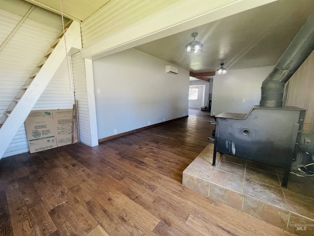 720 W 1st, Fairfield, ID 83327 - unfurnished living room with a wood stove, wood-type flooring, and a wall mounted air conditioner
