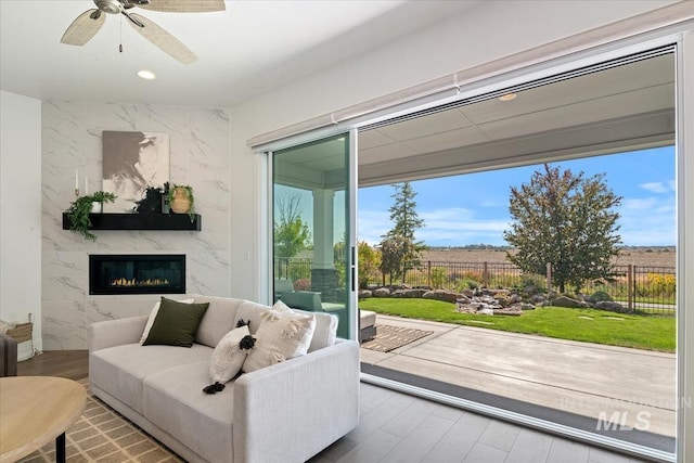 doorway to outside featuring a premium fireplace, wood finished floors, a ceiling fan, and recessed lighting